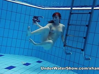 पूल में रेडहेडड प्यारा तैराकी नग्न